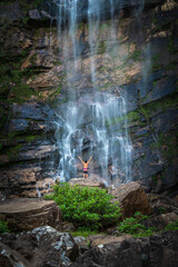 Beautiful view to man enjoying big natural wild waterfall