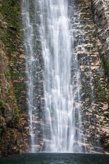 Fototapeta na wymiar Beautiful view to big wild rocky waterfall on green area