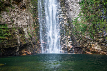 Fototapeta premium Beautiful view to big wild rocky waterfall on green area