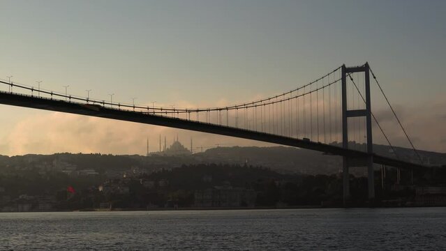 The Bosphorus Bridge (Turkish: Boğaziçi Köprüsü), known officially as the 15 July Martyrs Bridge (Turkish: 15 Temmuz Şehitler Köprüsü) and  Camlica Mosque in background from Ortakoy district.