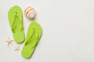 Flat lay composition with flip flops and seashell on colored background. Space for text top view