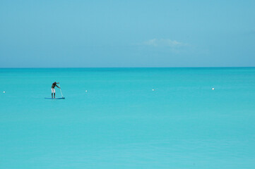 A paddle boarder on the calm Caribbean Ocean