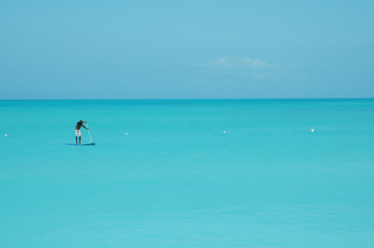 A Paddle Boarder On The Calm Caribbean Ocean