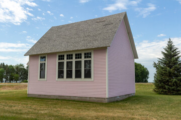 Close up view of an old pink country school house exterior with windows, built in the 1800’s in the midwestern USA