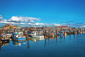 Fototapeta na wymiar Fishing Boats in Marina and a cloudy sky. This marina is located in the Steveston area of Richmond. The fishing village formed in this place was the first settlement on the territory of Richmond