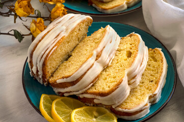 Top view of lemon cake with slices of lemons on blue plate. Delicious homemade baked dessert 