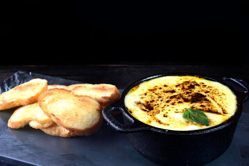 pan with meatballs rice cheese and salad, in iron pan on slate stone