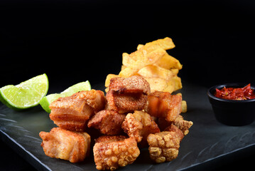 fried pork skin, pork rinds, typical Brazilian food, panceta with fried manioc, lime and pepper
