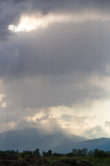 Thunderhead covers the Balkans. Downpour is approaching agricultural land. Villages, fields and...