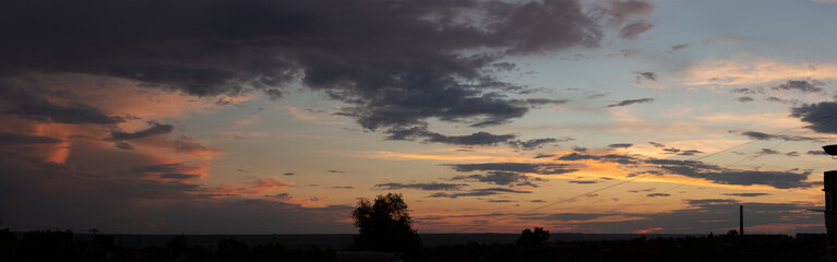 Landscape at sunset. Tragic gloomy sky. The village in the Budjak steppe. Panorama. Crimson twilight.