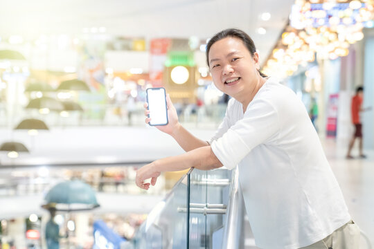 Orange Light effect in image of Asian long hair man who holds a bright screen smartphone. Although background is a little blurry, it sparkles nicely.