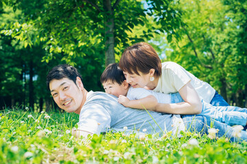 Fototapeta premium 草原に重なって寝そべる親子