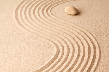 stone on sand with zen pattern. meditation harmony concept.