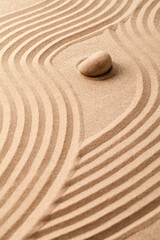 Fototapeta na wymiar stone on sand with zen pattern. meditation harmony concept.
