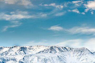 Fototapeta premium Snowy top of mountain range under blue sky