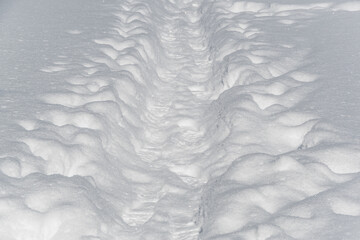Winter trail in snow among deep snowdrifts. Hiking after snowfall.