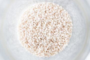 pantry jar with arborio risotto rice shot from top down perspective as close-up, simple staple...