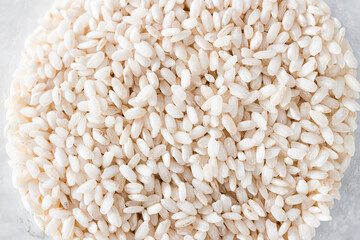 pantry jar with arborio risotto rice shot from top down perspective as close-up, simple staple ingredients
