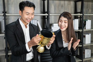 A successful business team holding a trophy. Concept of success. Happy, Excited young success business