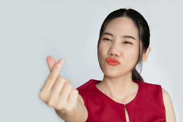 Asian beautiful woman make a mini heart gesturing  and blow kiss to express happiness and smiling for valentine's day. Love concept. a First love national day