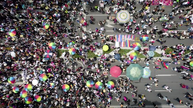 cenital drone shot of a crowd waving the gay pride flag at the pride parade in mexico city during june