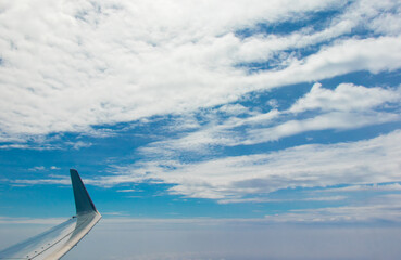 Aerial view of blue sky with clouds from the plane window.	
