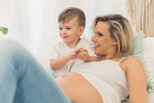portrait of a lovely little boy and his pregnant mom, happy family concept indoor. High quality photo