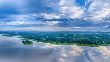 Big lake and island with green shores with morning fog in dawn, aerial landscape. Recreation concept. Aerial view