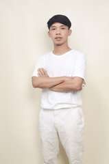 Portrait of asian young man standing with folded hands on isolated background