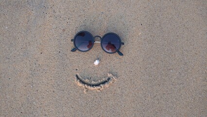 A decorated face drawn on the beach