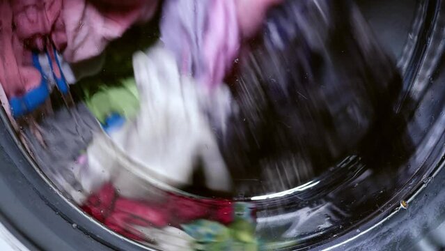 Clothes turn in the washing machine medium shot
