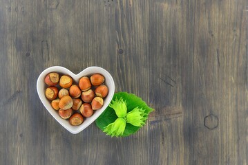 Fresh unshelled hazelnuts in a heart shaped dish