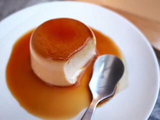 Delicious vanilla custard in caramel sauce with spoon
