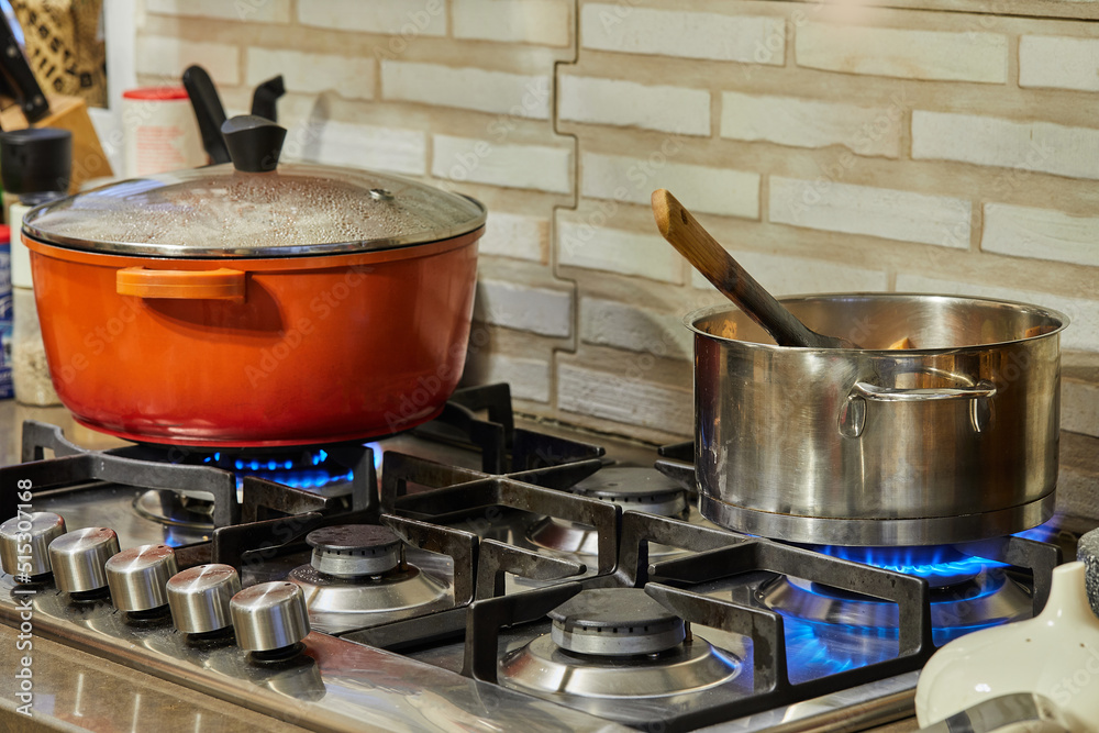 Sticker Preparing food in frying pan and casseroles on the gas stove in the kitchen. Home cooking concept