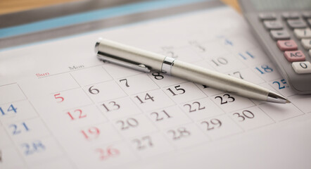 Calendar, calculator and pen on the desk. - obrazy, fototapety, plakaty