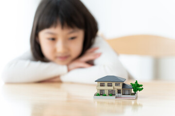 家の模型を眺める女の子