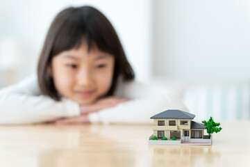 家の模型を眺める女の子