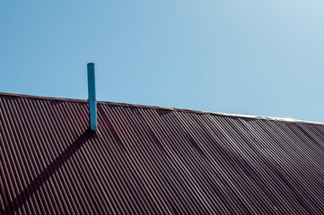 chimney on the roof of the house against the blue sky