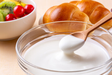朝食のヨーグルトをスプーンですくう