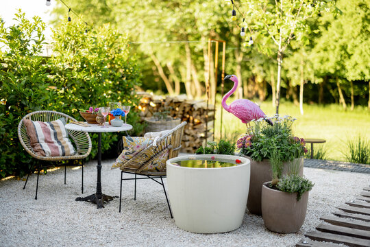 View on beautiful and cozy garden with coffee table, fountain and flamingo