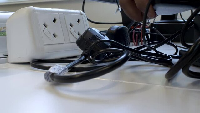 Close Up View Of Unplugging Electronic Devices from Electricity Socket, Power Saving Concept. Low Angle, Locked Off