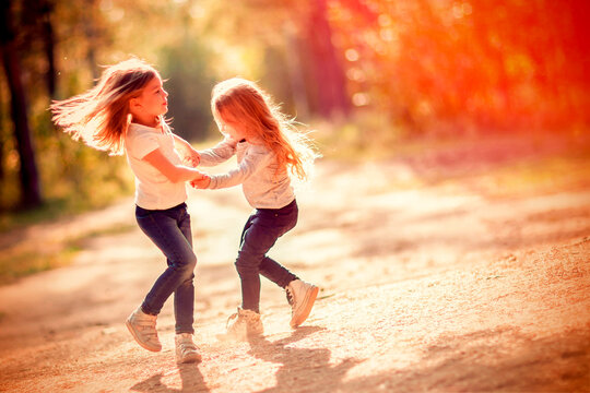 Two little girls dancing outdoors