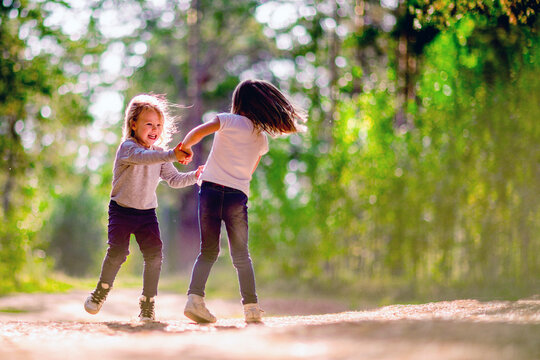 Two little girls dancing outdoors