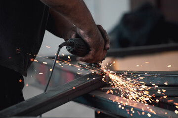 Close up on a man held an angle grinder to cut an iron with sparks