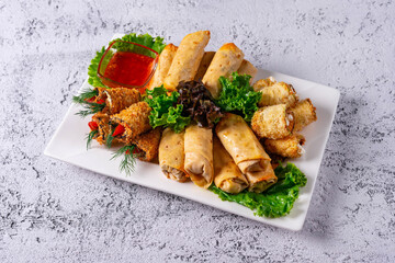 assorted, stuffed vegetables and rolls with sauce. on a light concrete background