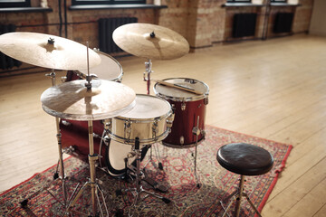 Horizontal image of drums set on carpet at empty musical studio