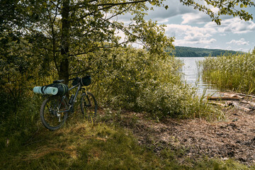 Fototapeta na wymiar A gravel bicycle with camping equipment for outdoor leisure activities. Summer adventures on the bike. Two travel mats on the front rack of the cycle.