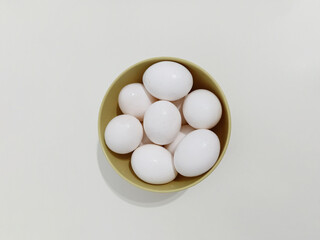 Top view, Many eggs, a bowl full of white eggs on a white background