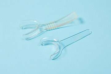 set of several Retractor Dental lip retractor Access to the oral cavity. Wide mouth opening for a dental procedure on a clean blue background