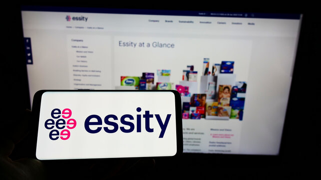 Stuttgart, Germany - 01-28-2022: Person holding cellphone with logo of Swedish consumer goods company Essity AB on screen in front of business webpage. Focus on phone display.